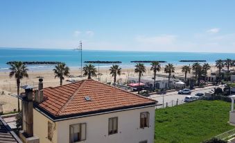 a beach with a view of the ocean , and a house on the left side of the road at Hotel Eden