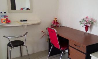 a small room with a desk , a chair , and a mirror on the wall , along with a red chair at Sacca Residence & Resto