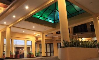 a large , well - lit hotel lobby with a glass ceiling , creating a warm and inviting atmosphere at Hotel Grand Papua Fakfak