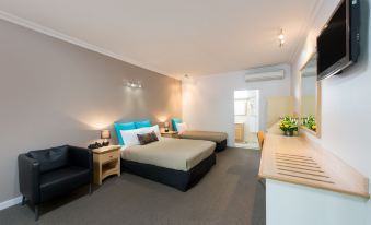 a modern hotel room with two beds , nightstands , and a desk , decorated with flowers and black furniture at Berri Hotel