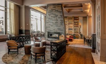 a spacious , well - lit room with a fireplace , couches , and other furniture , all under a large skylight at Raleigh Marriott City Center