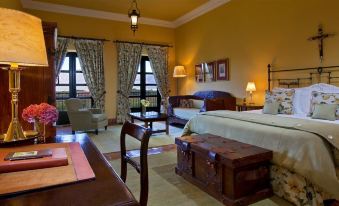 a luxurious hotel room with a large bed , wooden furniture , and a view of the city through the windows at Patios de Cafayate