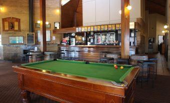 a pool table in a room , surrounded by various chairs and tables , creating an inviting atmosphere for playing games and socializing at Bremer Bay Resort