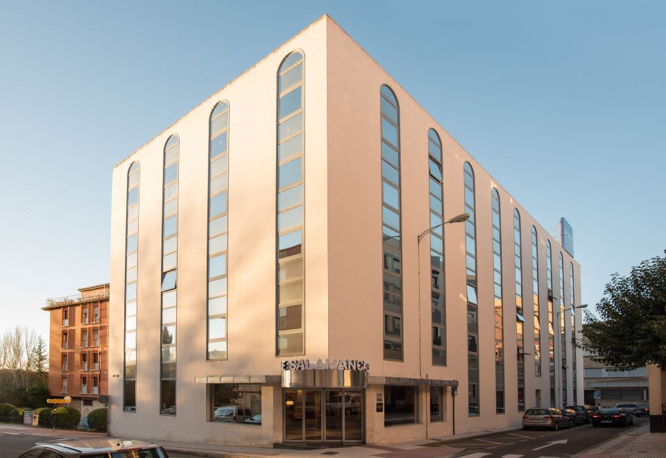 "a modern building with a large window and the name "" luxury "" written in blue above the entrance" at Exe Salamanca