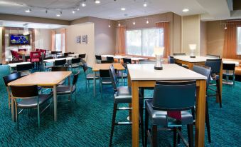 a large dining area with multiple tables and chairs , some of which are occupied by people at Sonesta Select Seattle Renton Suites