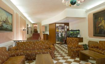 a large , well - lit room with a checkered floor and various furniture including couches , chairs , and tables at Hotel Nazionale