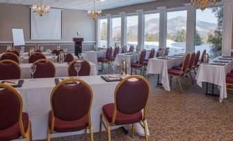a conference room set up for a meeting , with tables and chairs arranged in rows at White Mountain Hotel and Resort