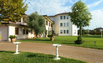 a large white house with a red roof is surrounded by a well - maintained lawn and trees at Hotel San Giovanni