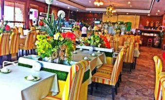 a well - decorated dining room with multiple tables and chairs , some of which are adorned with colorful decorations at Suanpa Resort