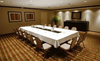 a long table with a white cloth and black centerpiece is set up in a conference room at Wyndham Minneapolis South/Burnsville