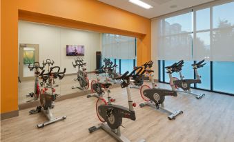 a well - equipped gym with various exercise equipment , including stationary bikes and treadmills , arranged in rows at Even Hotel Rockville - Washington, DC Area, an IHG Hotel