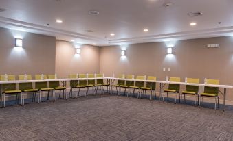 a conference room with green chairs and white tables , set up for a meeting or presentation at Holiday Inn Express Newington - Hartford