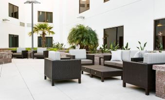 a patio area with a variety of outdoor furniture , including couches , chairs , and potted plants at Courtyard Redwood City