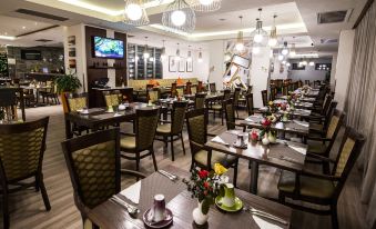 a well - decorated restaurant with multiple dining tables and chairs , creating a pleasant atmosphere for guests at Hotel Verde Cape Town Airport