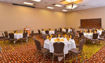 a large conference room with multiple tables and chairs , all set for a meeting or event at Ramada Plaza by Wyndham Sheridan Hotel & Convention Center