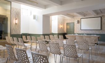 a large , empty conference room with rows of chairs arranged in a semicircle around a podium at Chateau de Fonscolombe