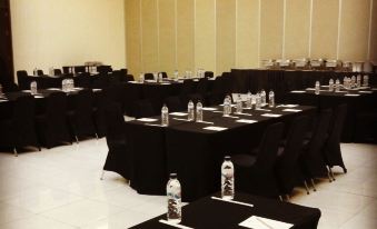 a large conference room set up for a meeting , with tables and chairs arranged in rows at De View Hotel