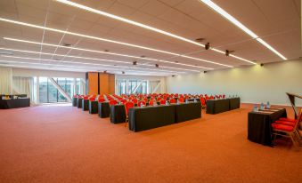 a large conference room with multiple rows of tables and chairs arranged for a meeting or event at Exe Layos Golf