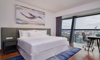 a bedroom with large windows and a white bed in the center, offering a view of the outdoors at Element Kuala Lumpur