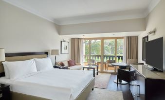 a large bedroom with a king - sized bed and a sliding glass door that leads to a balcony at Marriott Mena House, Cairo