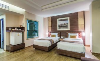 a modern hotel room with two beds , a window , and a kitchenette , along with wooden flooring and white walls at Gallery Design