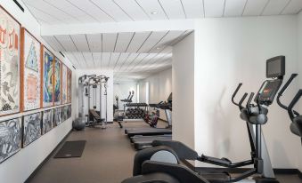 a well - equipped gym with various exercise equipment , including treadmills and stationary bikes , in a well - lit room at The Williams Inn