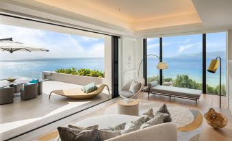 a modern living room with a large window offering a view of the ocean , featuring comfortable seating and modern furniture at Halekulani Okinawa