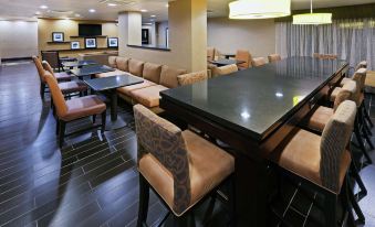 a dining area with several tables and chairs , along with a tv mounted on the wall at Grayson Manor