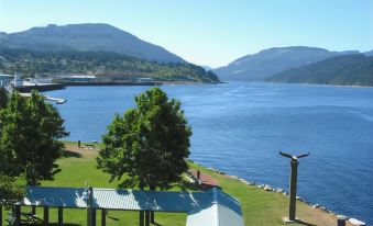 a serene lake with mountains in the background , and a dock extending into the water at Best Western Plus Barclay Hotel