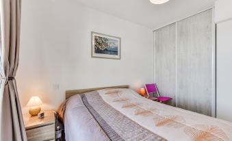 a neatly made bed with a white comforter and pillows , next to a wooden nightstand at Balnea