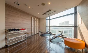 a modern gym with various exercise equipment , including treadmills and weight machines , in a spacious room with large windows at HOTEL MYSTAYS Utsunomiya