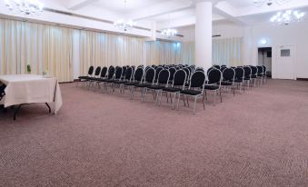 a large conference room with rows of chairs arranged in a semicircle , ready for an event at Albany Hotel