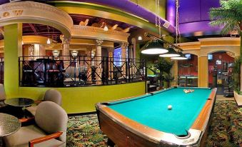 a large pool table in a room with multiple chairs and a purple ceiling , creating an inviting atmosphere at Red Lion Inn and Suites Victoria