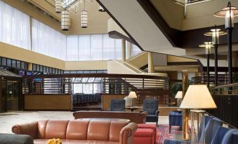 a large hotel lobby with various seating options , including couches and chairs , as well as a television at Sheraton Philadelphia Downtown