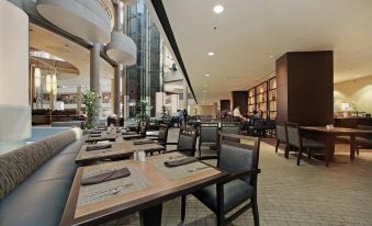 a modern dining room with wooden tables and chairs , surrounded by bookshelves and large windows at The Westin Bonaventure Hotel & Suites, Los Angeles