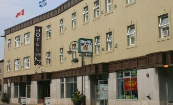 a building with a sign for a hotel and a flag flying in front of it at Hotel du Nord