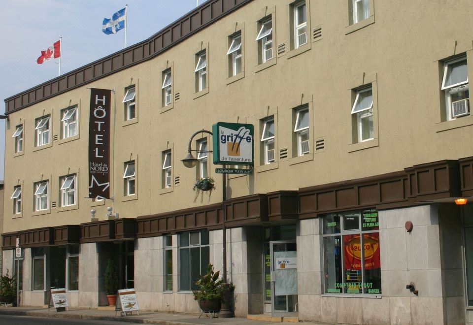 a large building with a sign for the hotel and the hotel sign for the orchard are visible at Hotel du Nord