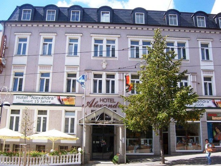 a city street with a hotel building on the left side of the scene , and a smaller hotel building on the right side at Hotel Alexandra