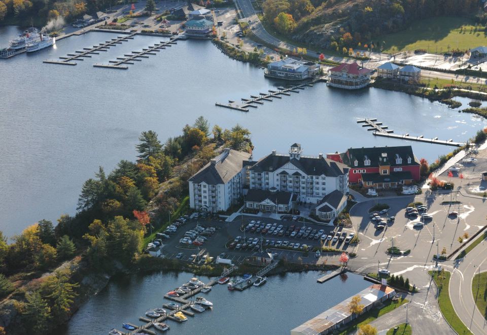 an aerial view of a marina with several boats docked , surrounded by buildings and trees at Residence Inn Gravenhurst Muskoka Wharf