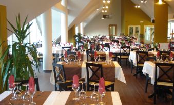 a large dining room with tables and chairs arranged for a group of people to enjoy a meal together at Eira do Serrado - Hotel & Spa