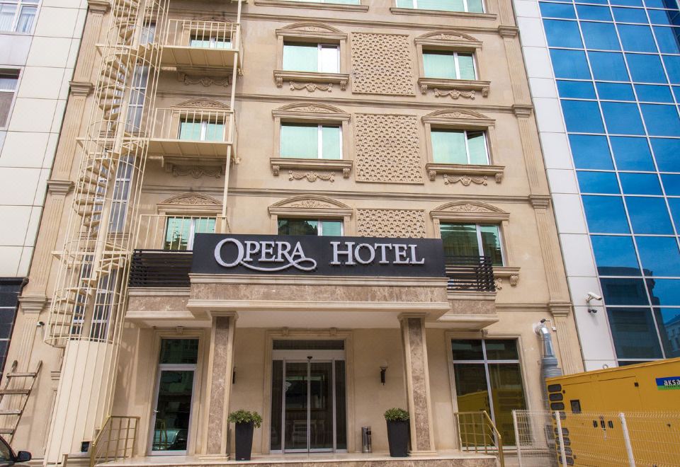"a large hotel building with a sign that reads "" opera hotel "" prominently displayed on the front of the building" at Opera Hotel