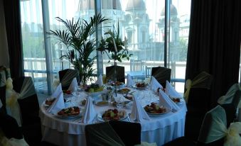 a dining room with a table set for a formal dinner , featuring a variety of dishes and utensils at Grand Hotel