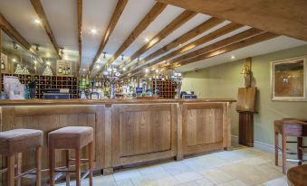 a wooden bar with various bottles and glasses on it , along with a stool for patrons to sit and enjoy the ambiance at Wild Thyme & Honey