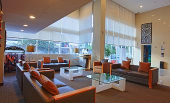 a modern hotel lobby with various seating options , including couches , chairs , and a coffee table at Metland Hotel Cirebon by Horison