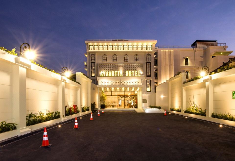 "the hotel is lit up at night , with a sign that reads "" hyatt hotel "" in front of it" at Ayaartta Hotel Malioboro