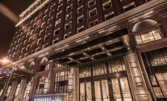 "a large , ornate building with a blue sign that says "" muizenburg "" is lit up at night" at Hotel Valletta