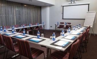 a conference room set up for a meeting with multiple tables and chairs arranged in a semicircle at Radisson Blu Resort, Gran Canaria