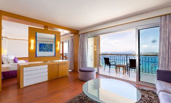 a modern living room with a large window and sliding glass door leading to an ocean view at Kefaluka Resort