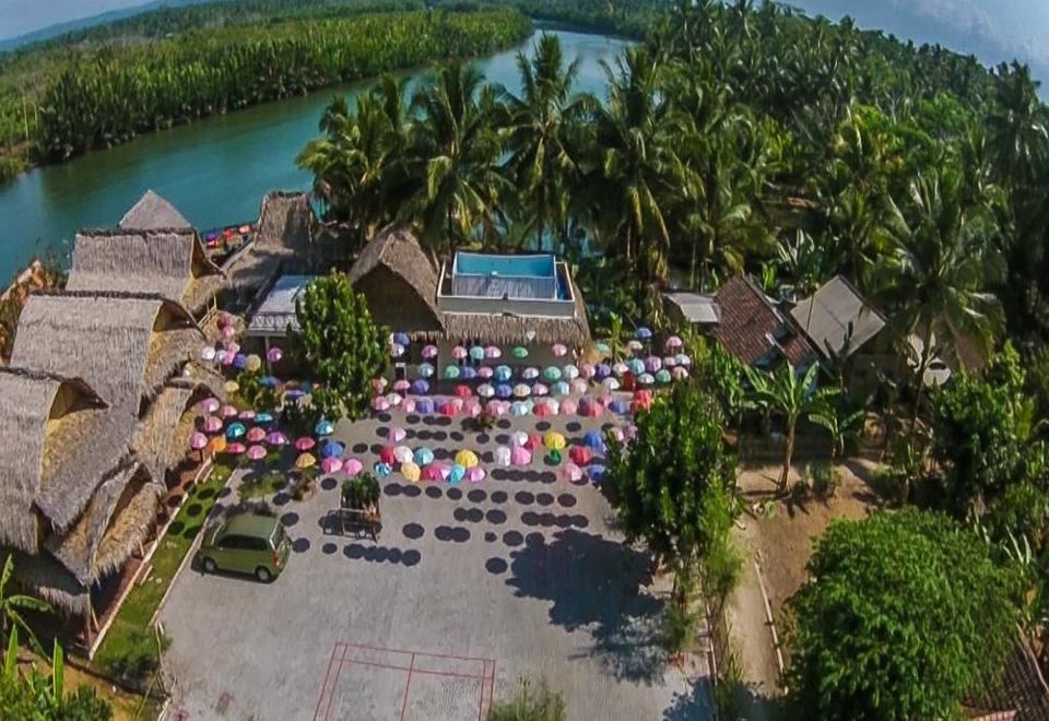 a bird 's eye view of a tropical resort with palm trees , buildings , and a lake at Shane Josa Resort