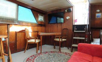 a cozy living room with wooden walls , a red couch , and a television mounted on the wall at Cookie B